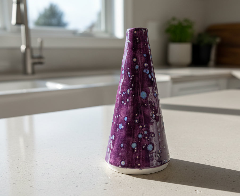 Purple ceramic oil bottle with white and blue patterns on a kitchen counter